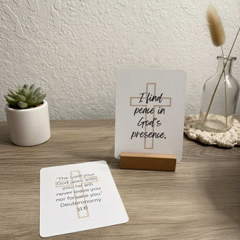 Two motivational cards on a wooden surface with a plant and decorative items in the background.